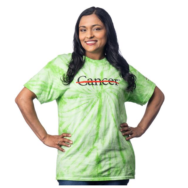 MD Anderson employee wearing a lime Tie-Dye shirt featuring the black cancer strikethrough logo on the chest and the full black MD Anderson logo on the sleeve.