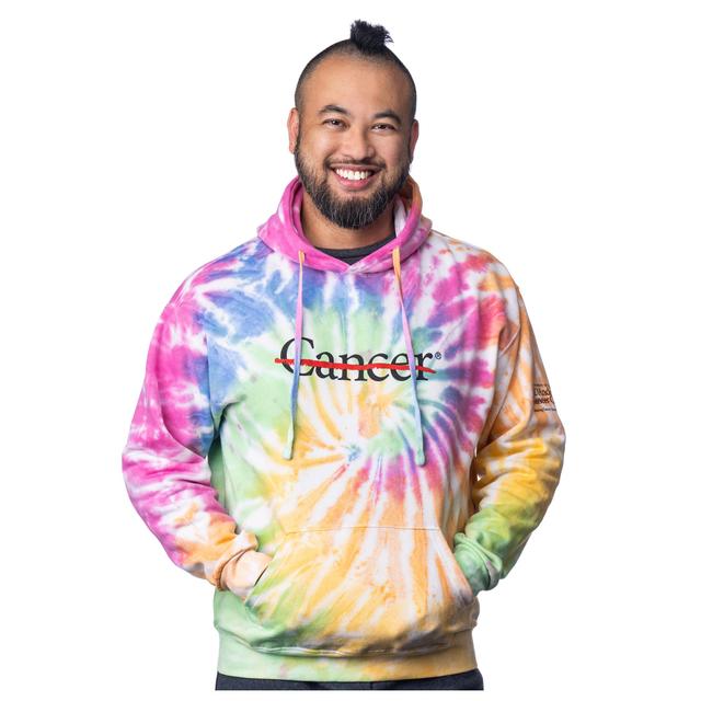 MD Anderson employee wearing a tie-dye sweatshirt featuring the black cancer strikethrough logo on the chest area and the black MD Anderson logo on the sleeve.