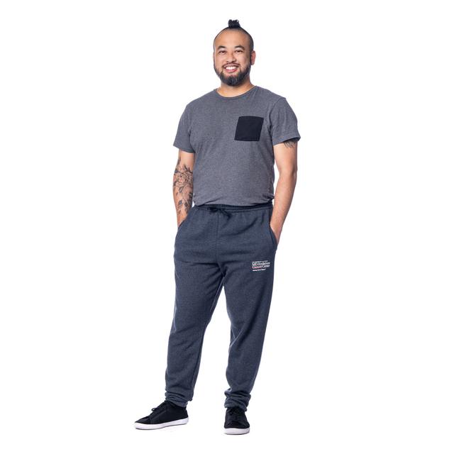 MD Anderson employee wearing the heather black fleece jogger pants with the white MD Anderson logo embroidered on the upper thigh area.