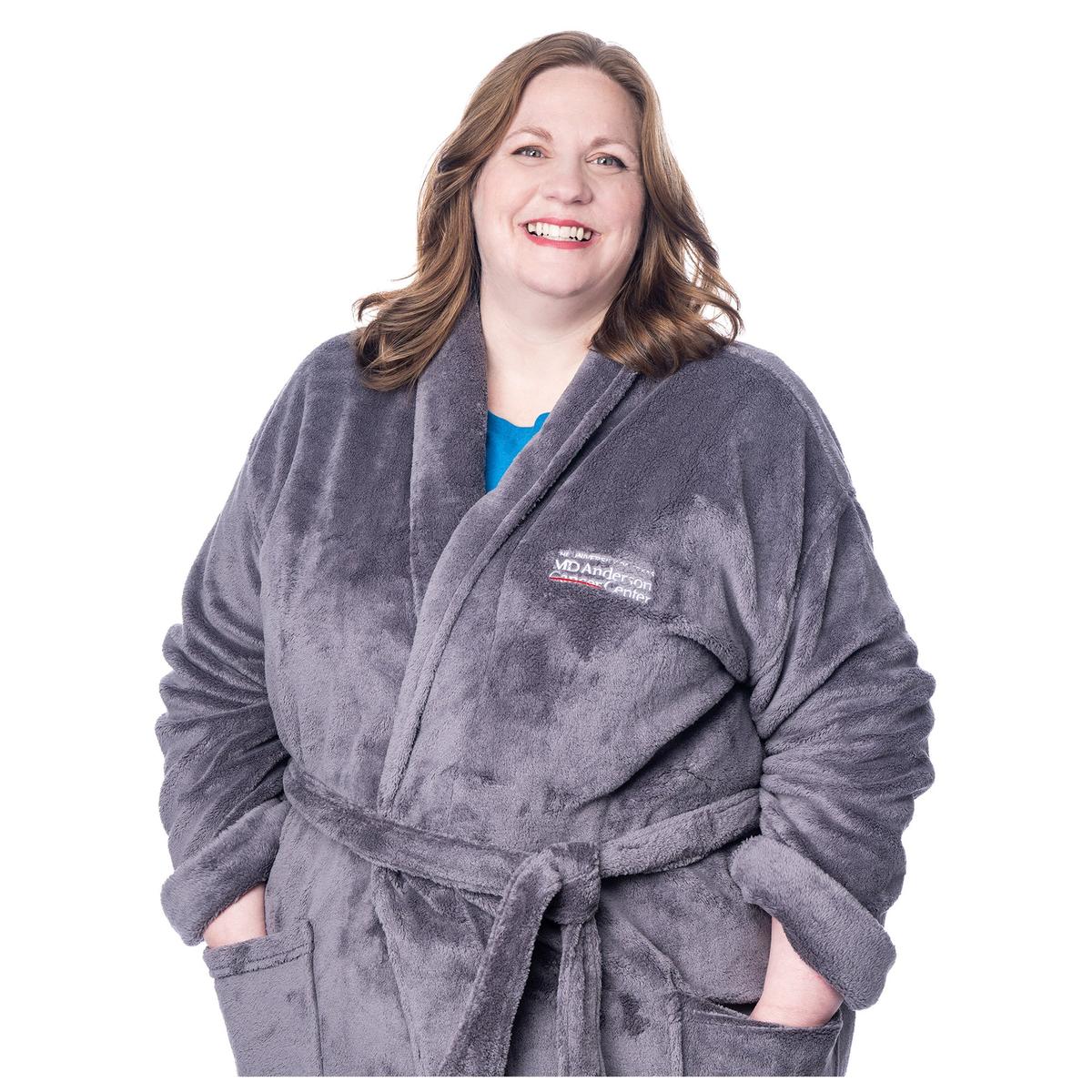 Closeup of MD Anderson employee wearing a gray plush robe with belt featuring the white MD Anderson logo on the chest area.