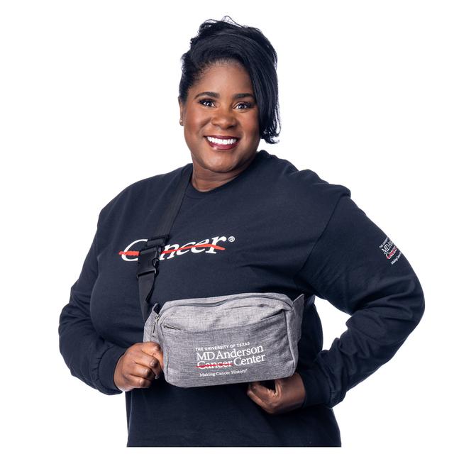 MD Anderson employee sporting a grey fanny pack with black straps featuring the white MD Anderson logo.  Edit alt text