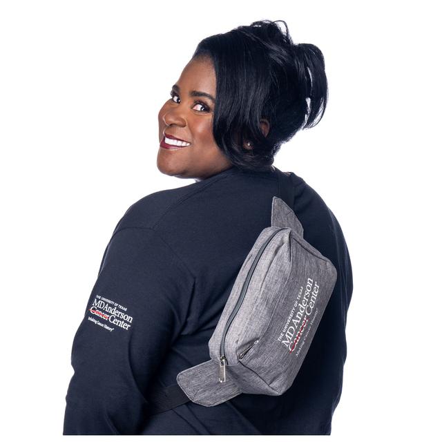 MD Anderson employee sporting a grey fanny pack with black straps featuring the white MD Anderson logo.