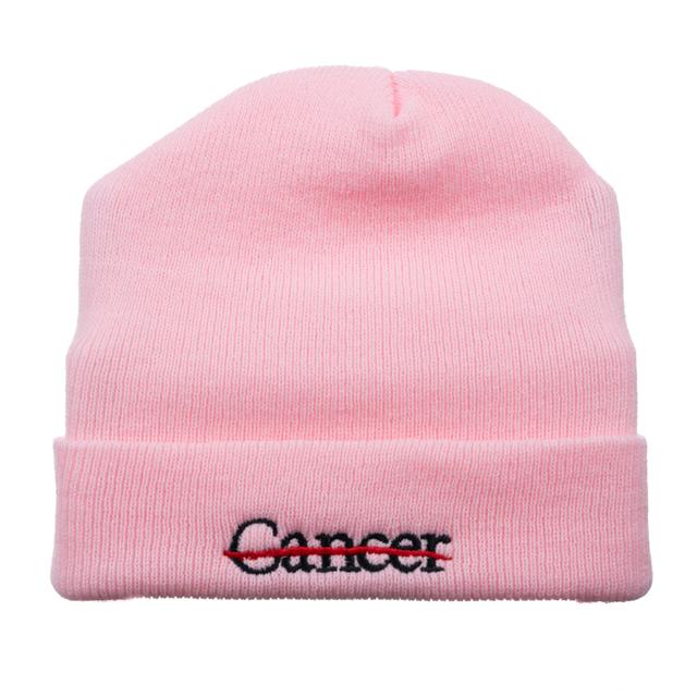 Pink beanie featuring the black cancer strikethrough logo.