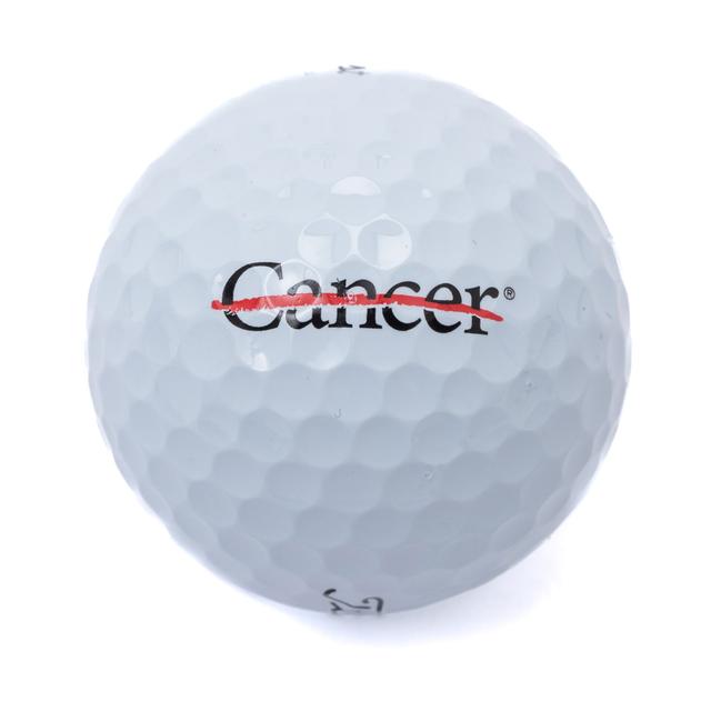 White golf ball featuring the black cancer strikethrough logo.